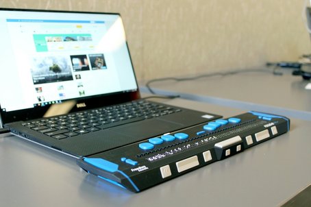 Laptop connected to a refreshable braille display, demonstrating accessible technology for visually impaired users.