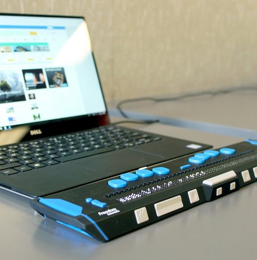 Laptop connected to a refreshable braille display, demonstrating accessible technology for visually impaired users.