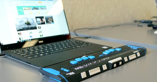 Laptop connected to a refreshable braille display, demonstrating accessible technology for visually impaired users.