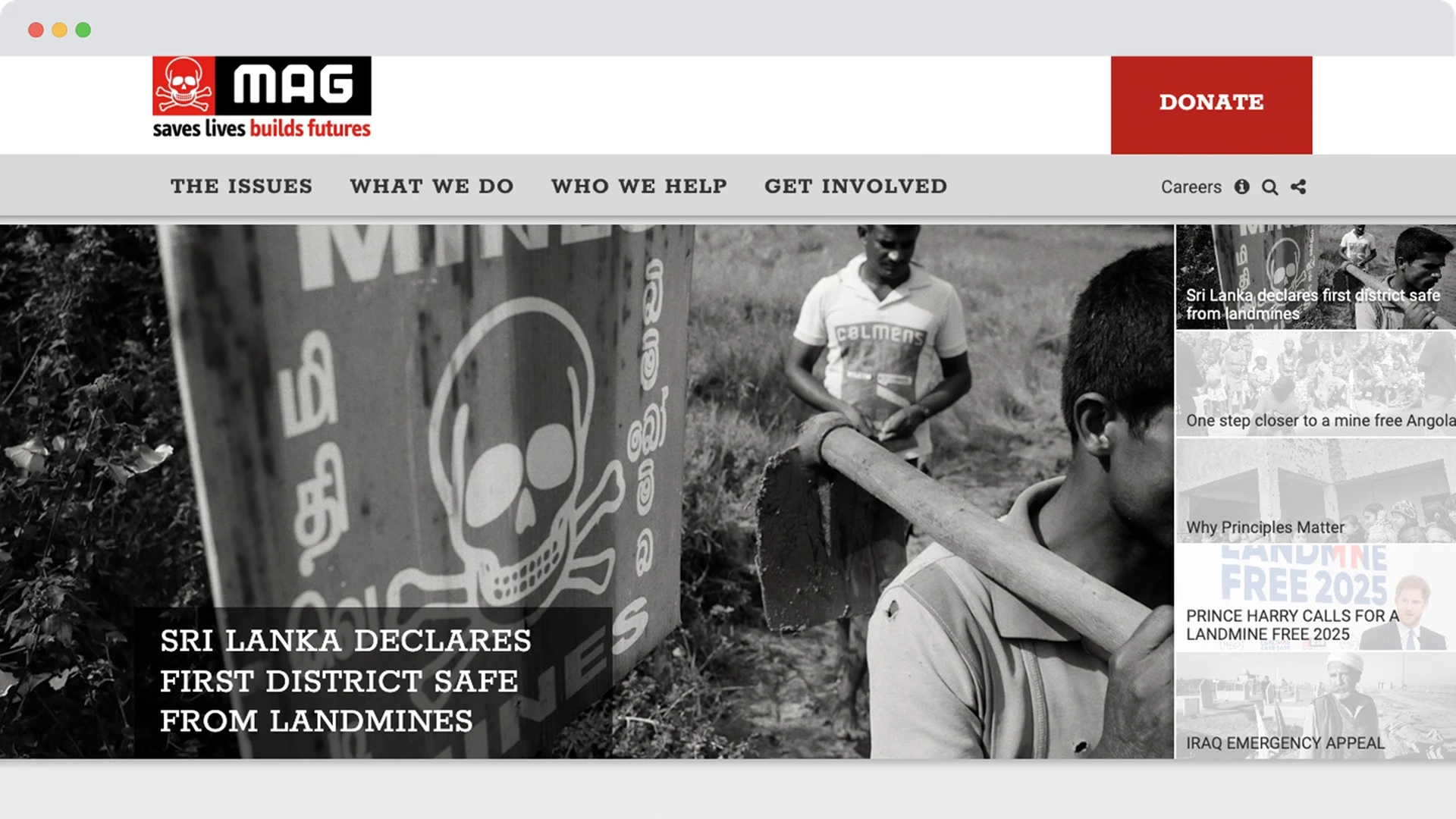 A black and white photo of a man walking past a skull-marked mine warning sign in Sri Lanka, with others working in the background to clear land.