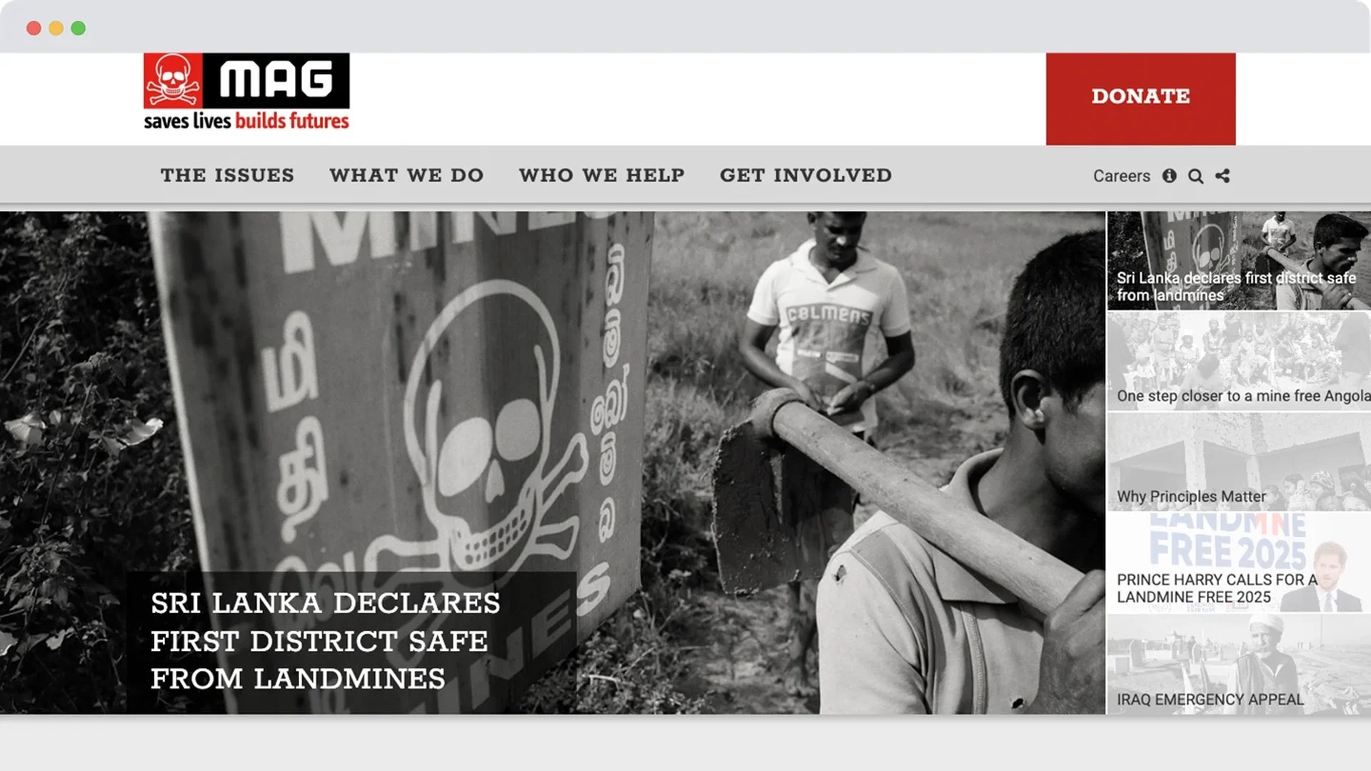A black and white photo of a man walking past a skull-marked mine warning sign in Sri Lanka, with others working in the background to clear land.