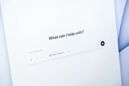 Close-up of a screen displaying the ChatGPT interface with the prompt "What can I help with?" and options for asking questions, representing AI-assisted search or support.