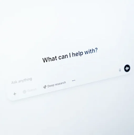 Close-up of a screen displaying the ChatGPT interface with the prompt "What can I help with?" and options for asking questions, representing AI-assisted search or support.