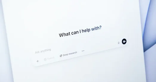 Close-up of a screen displaying the ChatGPT interface with the prompt "What can I help with?" and options for asking questions, representing AI-assisted search or support.