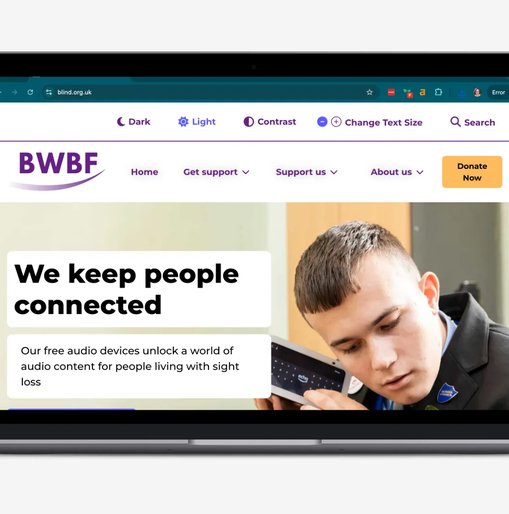 A laptop on a light grey background displaying the homepage of BWBF